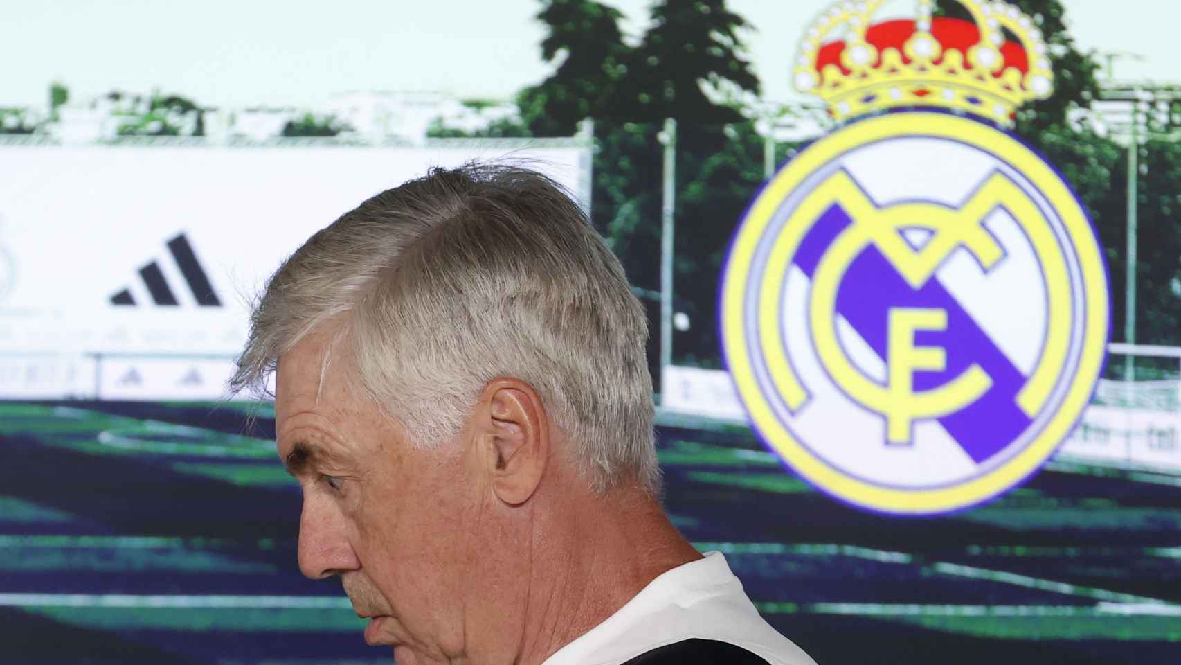Ancelotti, junto al escudo del Real Madrid.