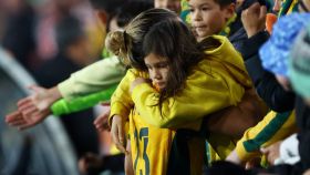 Una joven aficionada es consolada por una futbolista de Australia