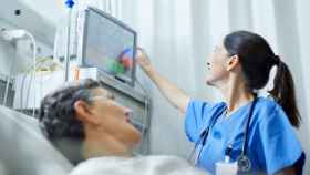 Imagen de archivo de una sanitaria mirando a una pantalla y una paciente a su lado.