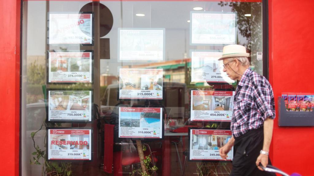 Un hombre pasa delante del escaparate de una inmobiliaria.