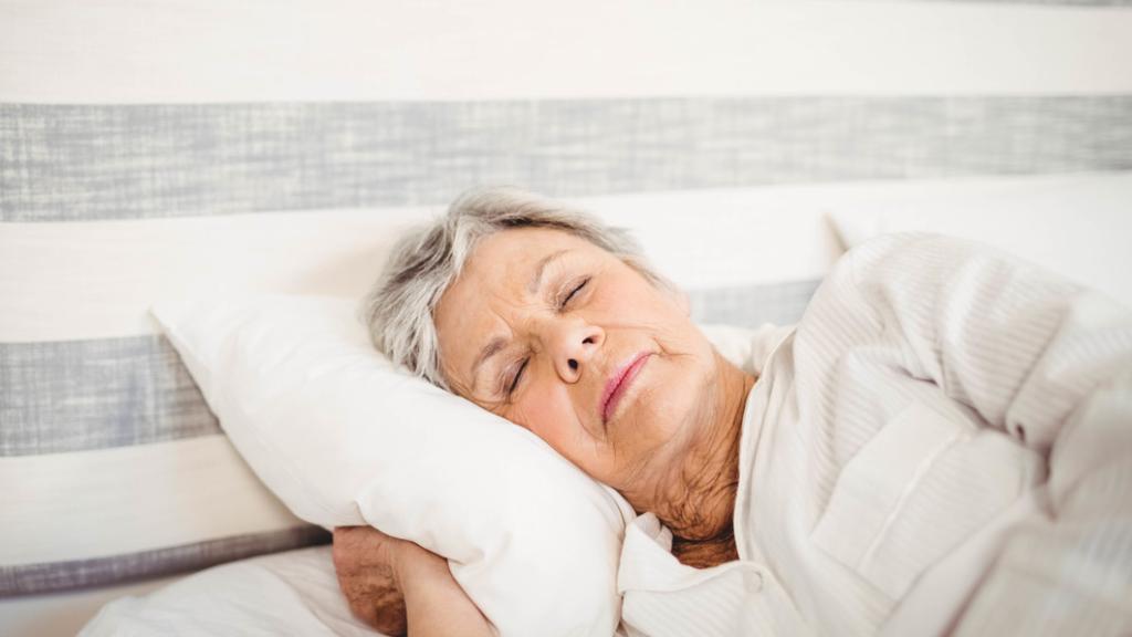 Imagen de archivo de una mujer mayor descansando en una cama.