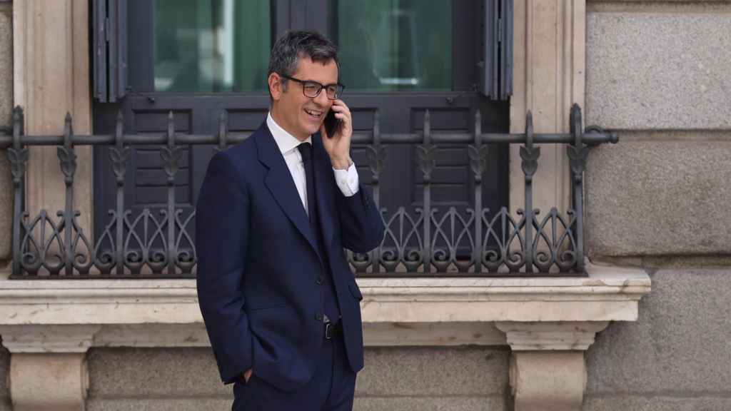 Félix Bolaños, ministro de la Presidencia, habla por teléfono en el patio del Congreso.