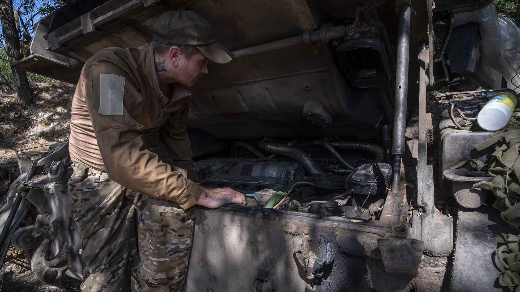 El mécanico de un carro de combate de la 17 Brigada revisa el motor del vehículo antes de que emprenda una nueva misión en el campo de batalla de Klishchiivka