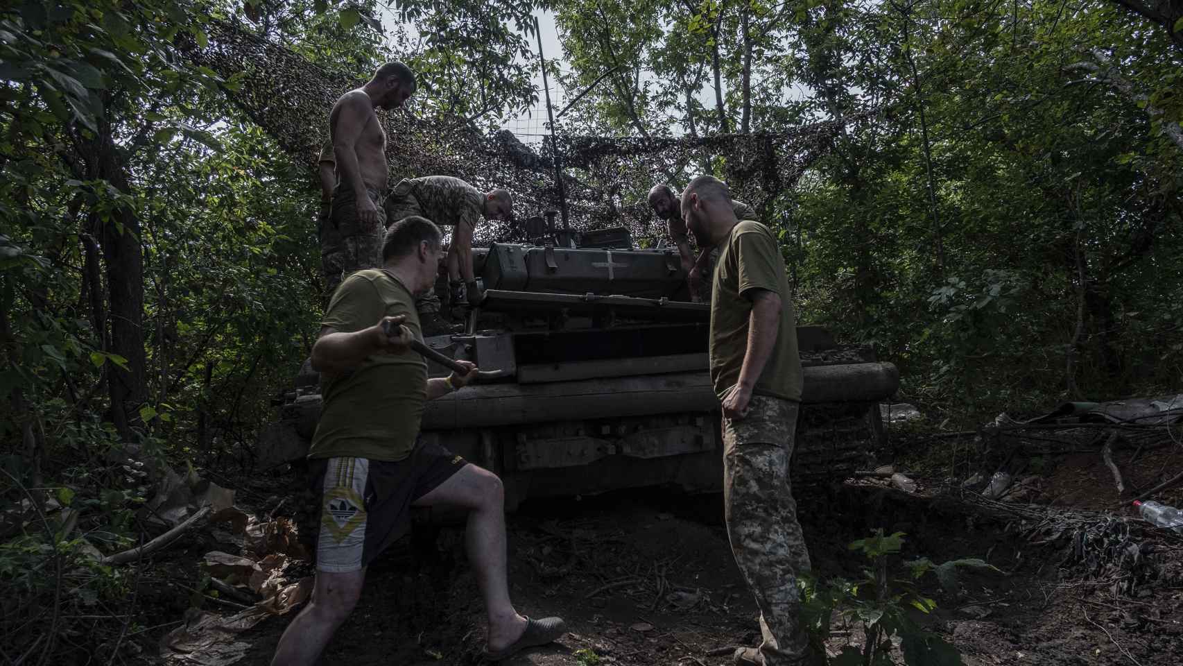 Los tripulantes de un carro de combate T-64, de la 17 Brigada del Ejército ucraniano, reparan el vehículo tras una misión, en pleno frente de Donetsk