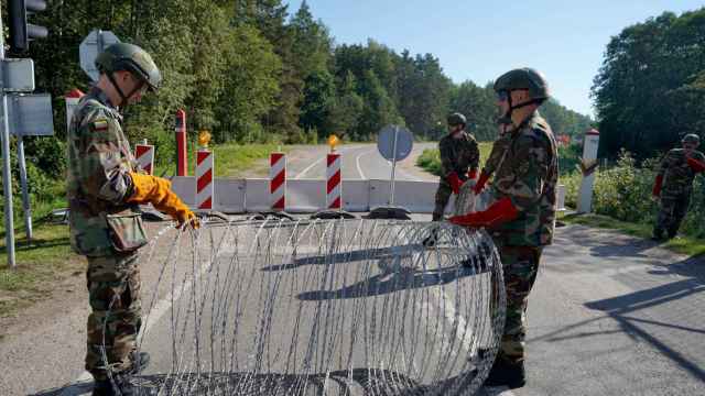 Miembros de la Unión de Fusileros de Lituania instalan alambre en el cruce fronterizo con Bielorrusia.