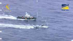 El velero rodeado por embarcaciones de la Guardia Civil y observado por un helicóptero.