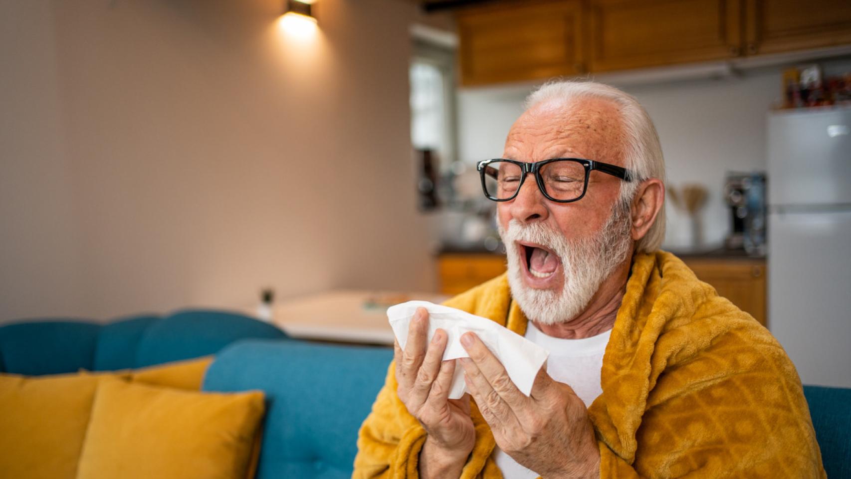 Un anciano estornudando.