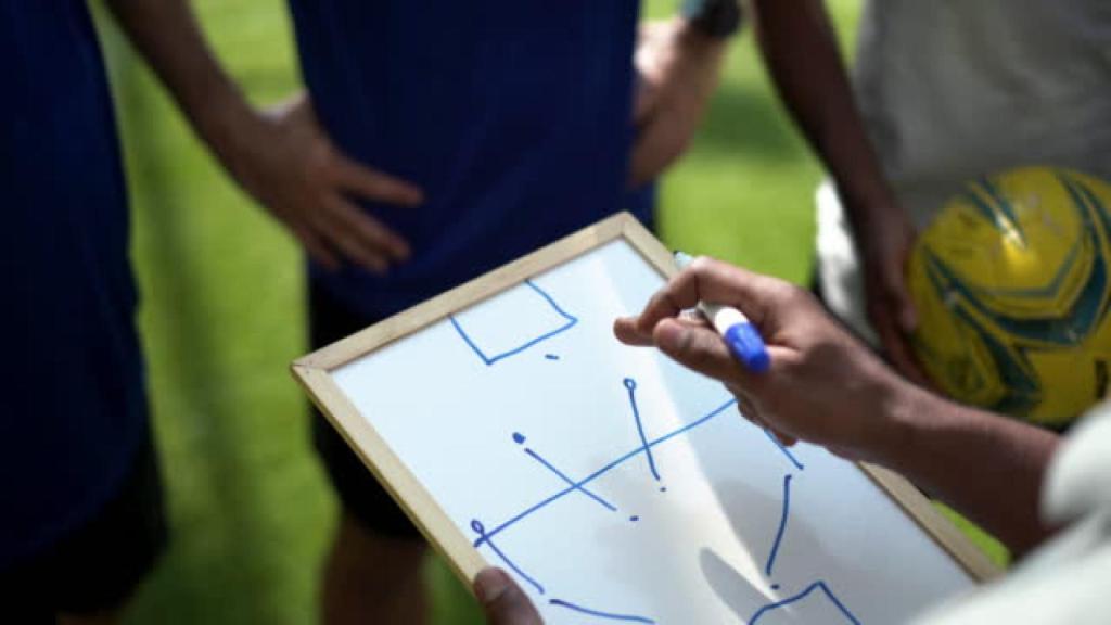 Imagen de archivo de un entrenador de fútbol da indicaciones a sus jugadores