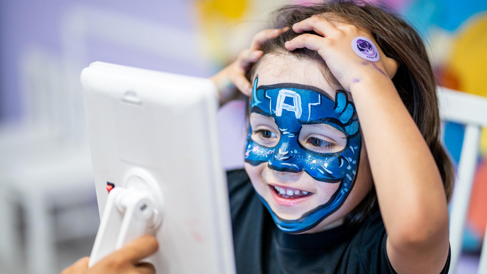 Niño con la cara pintada en un taller.