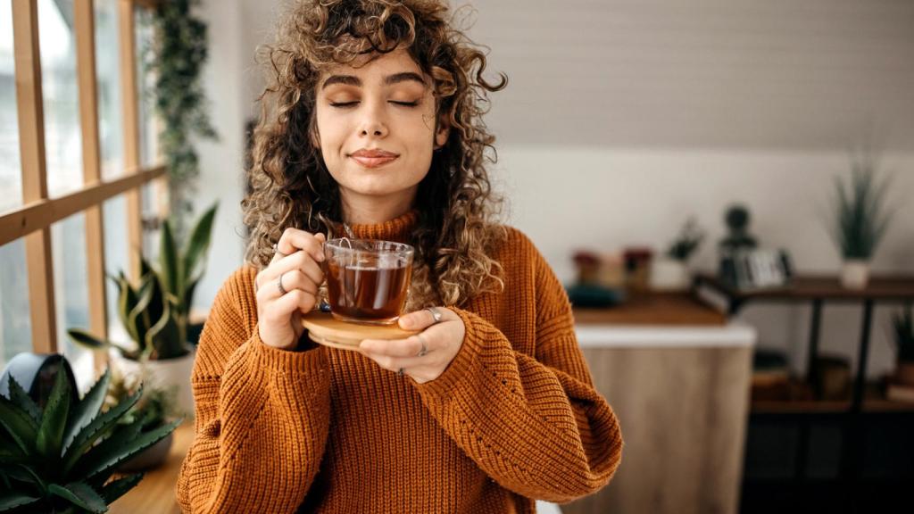 Una mujer, oliendo su té.