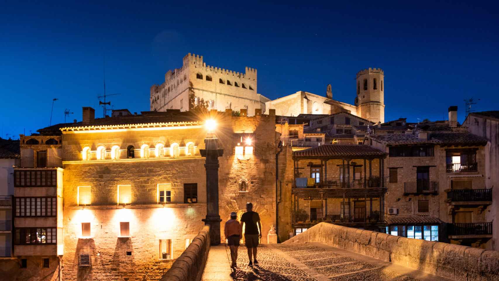 Imagen de una pareja paseando de noche por el centro histórico de Teruel.