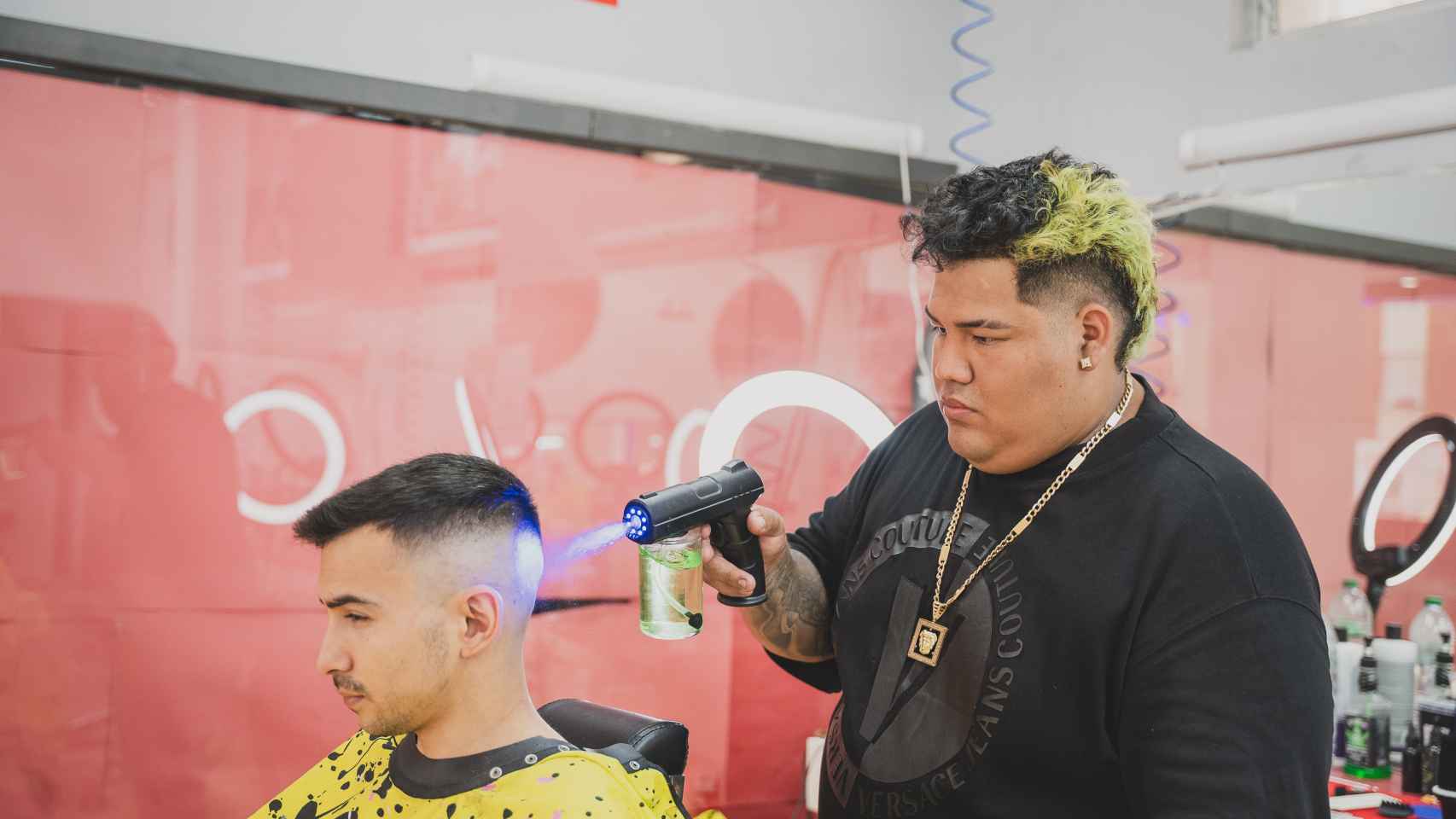 El barbero mojándole el pelo a José Luis, un cliente recién mudado al barrio que iba por primera vez.