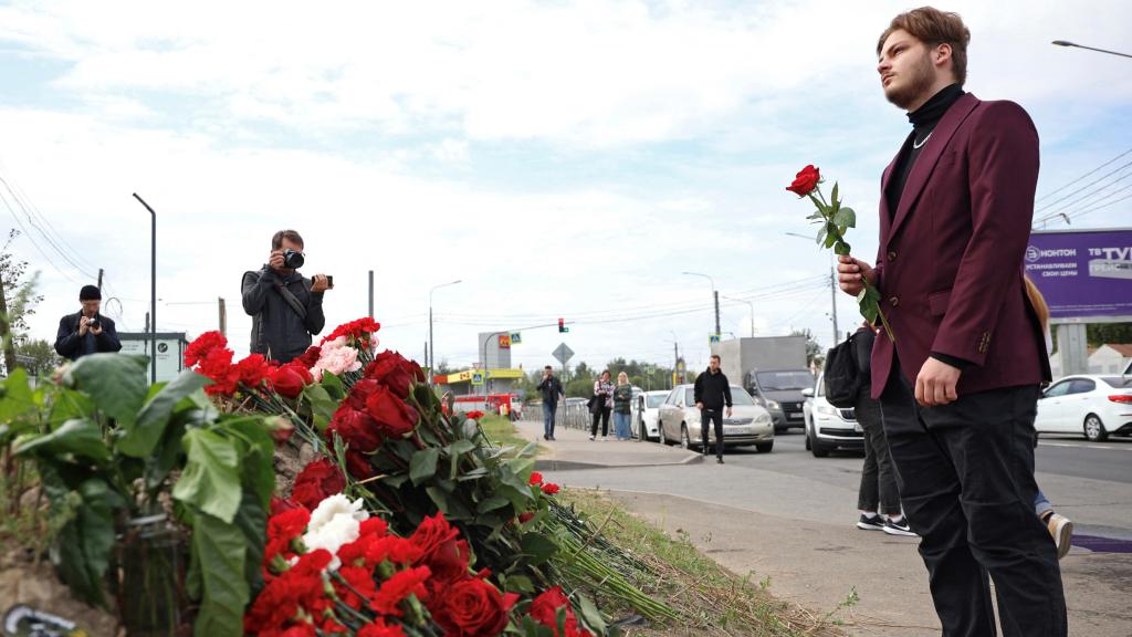 Un joven deja flores en homenaje a Prigozhin en San Petersburgo.