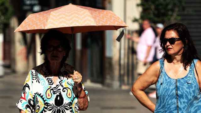 Una mujer se protege del sol este verano en las calles de Valencia.
