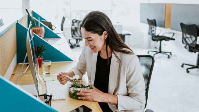Una mujer comiendo sano en la oficina.