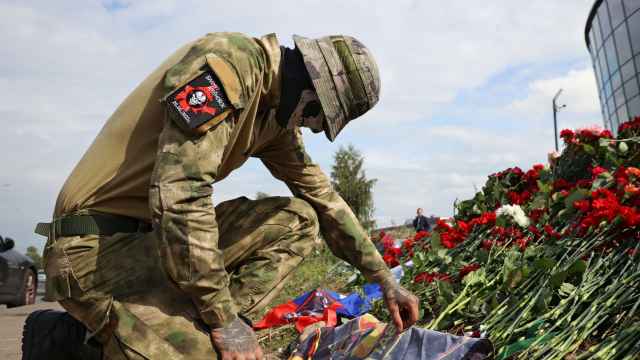 Un soldado del Grupo Wagner deposita unas flores en el exterior de la sede de los mercenarios