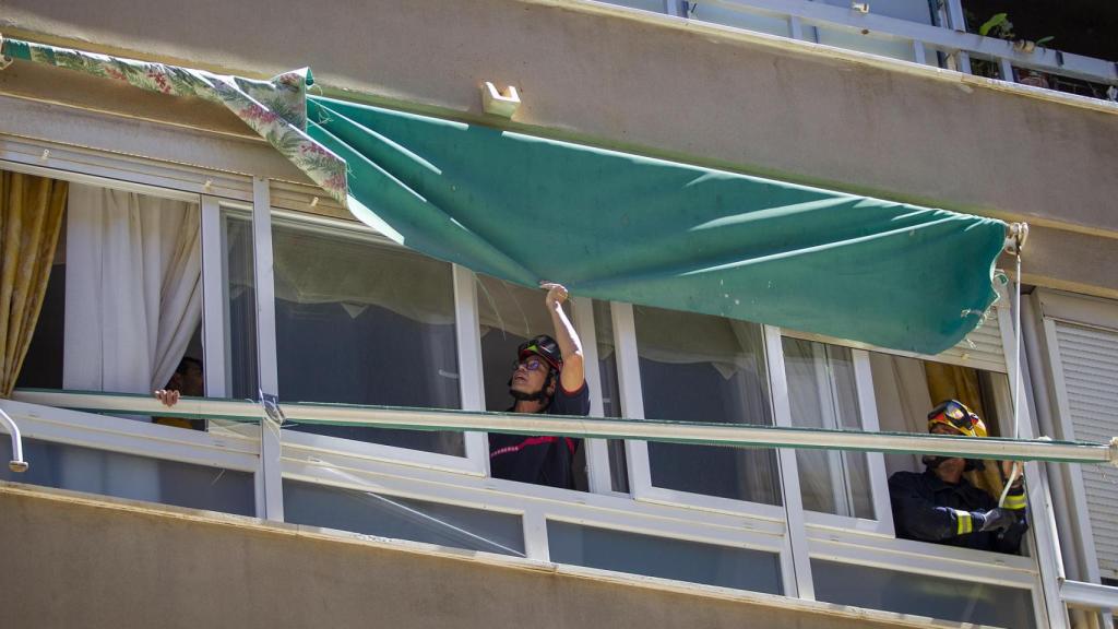 Los bomberos de Málaga comprobando un toldo por el viento.