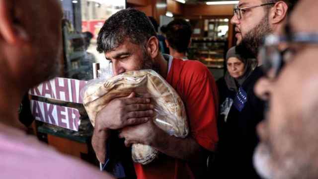 Un hombre besa el pan que acaba de comprar por la crisis de cereales de Líbano.