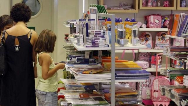 Una mujer realizando compras de la vuelta al cole en una tienda.