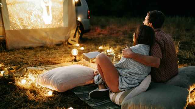Una pareja ve una película al aire libre por la noche.