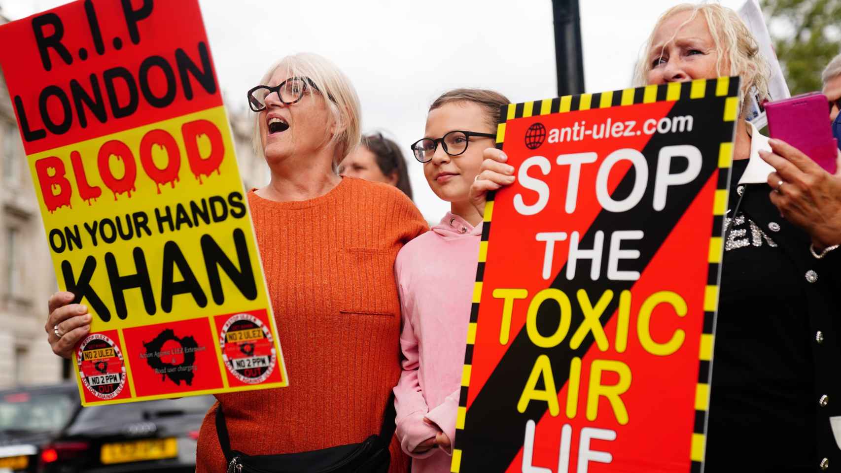Manifestantes sostienen pancartas frente a Downing Street contra la ampliación de la zona de emisiones ultrabajas.