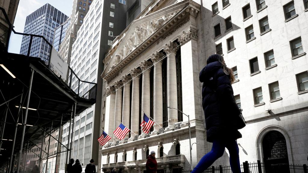 Gente pasea delante de la Bolsa de Nueva York, en Wall Street.