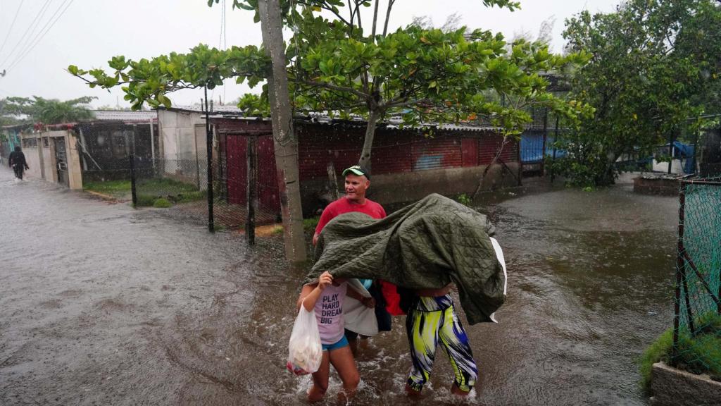 Una familia en plena evacuación por el huracán Idalia, este lunes en Guanimar, Cuba.