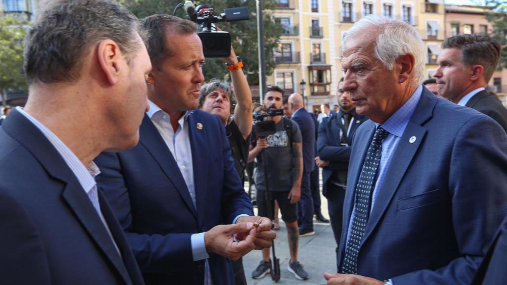 Carlos Velázquez le entrega sus gemelos a Josep Borrell.