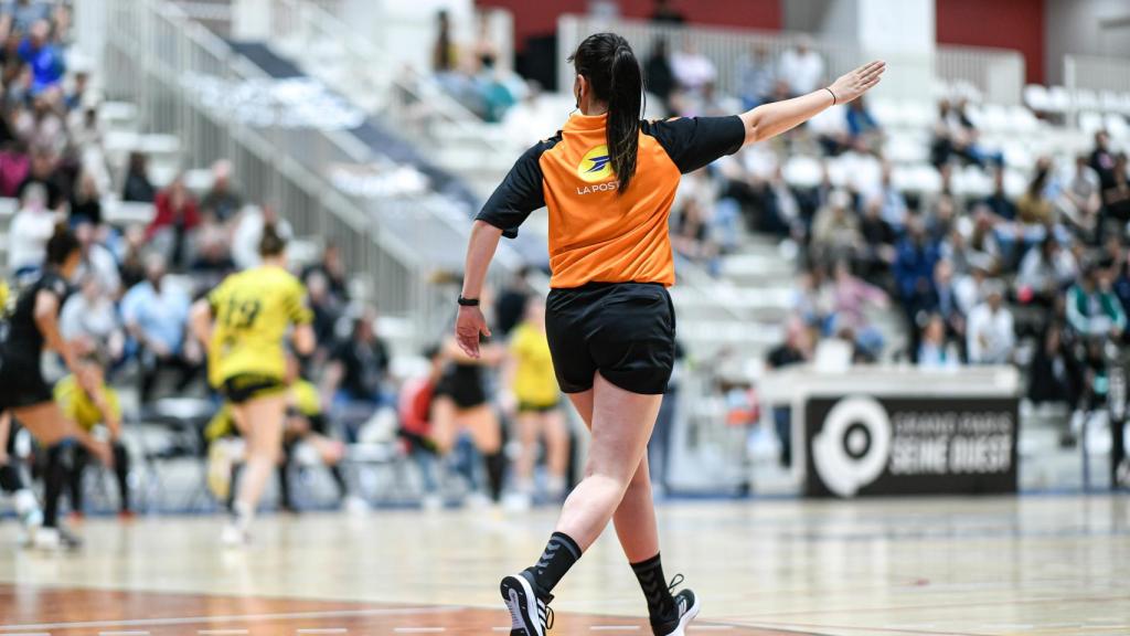 Una árbitra en un partido de balonmano femenino.