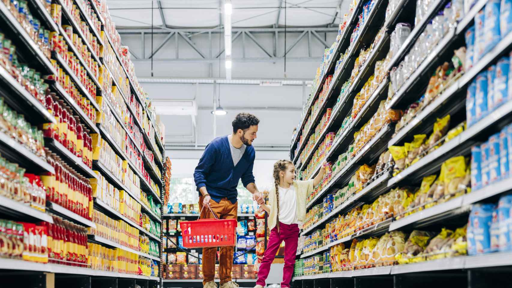 Una niña haciendo la compra con su padre en el supermercado