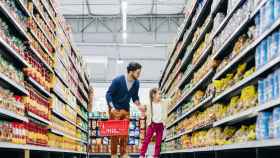 Una niña haciendo la compra con su padre en el supermercado