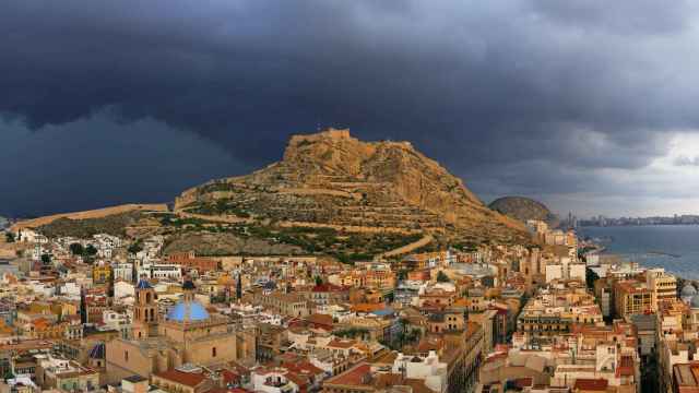 La ciudad de Alicante un día lluvioso con el castillo de San Fernando detrás.