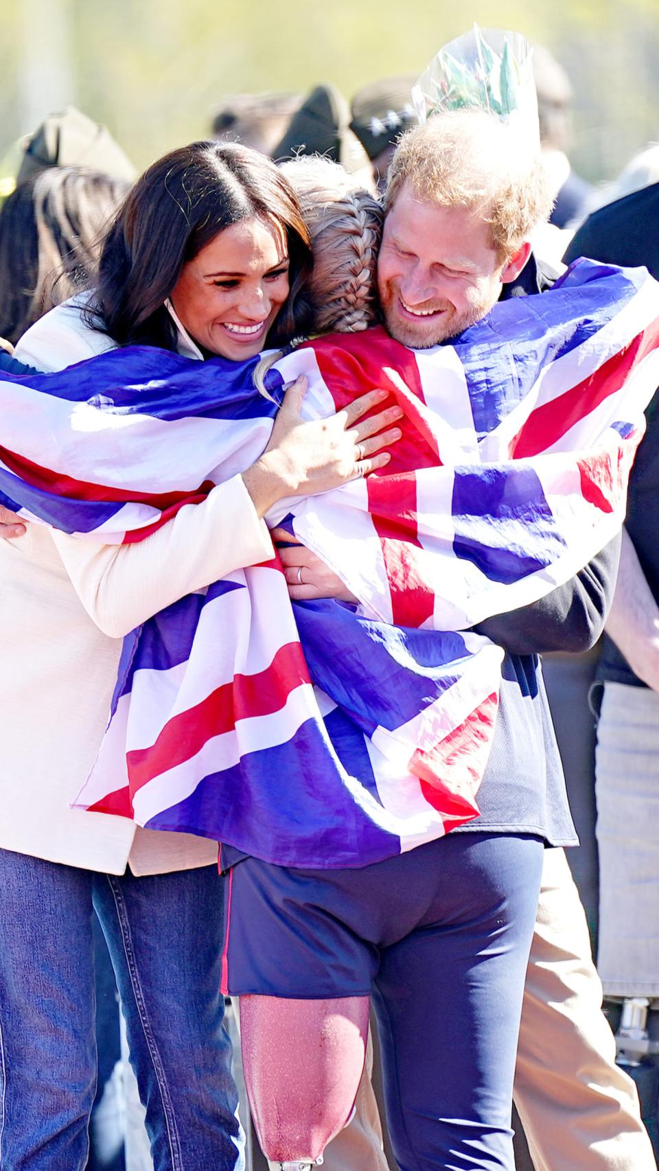 Meghan Markle y Harry de Inglaterra abrazando a una participante en el documental.