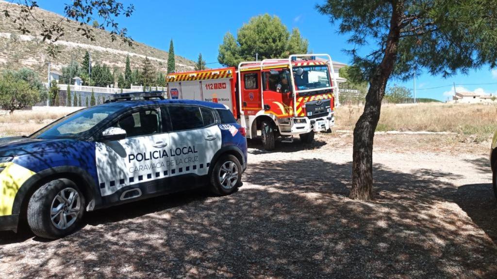 Un coche patrulla de la Policía Local de Caravaca de la Cruz y un camión de bomberos del CEIS, este jueves, junto al estanque en el que ha muerto la niña.