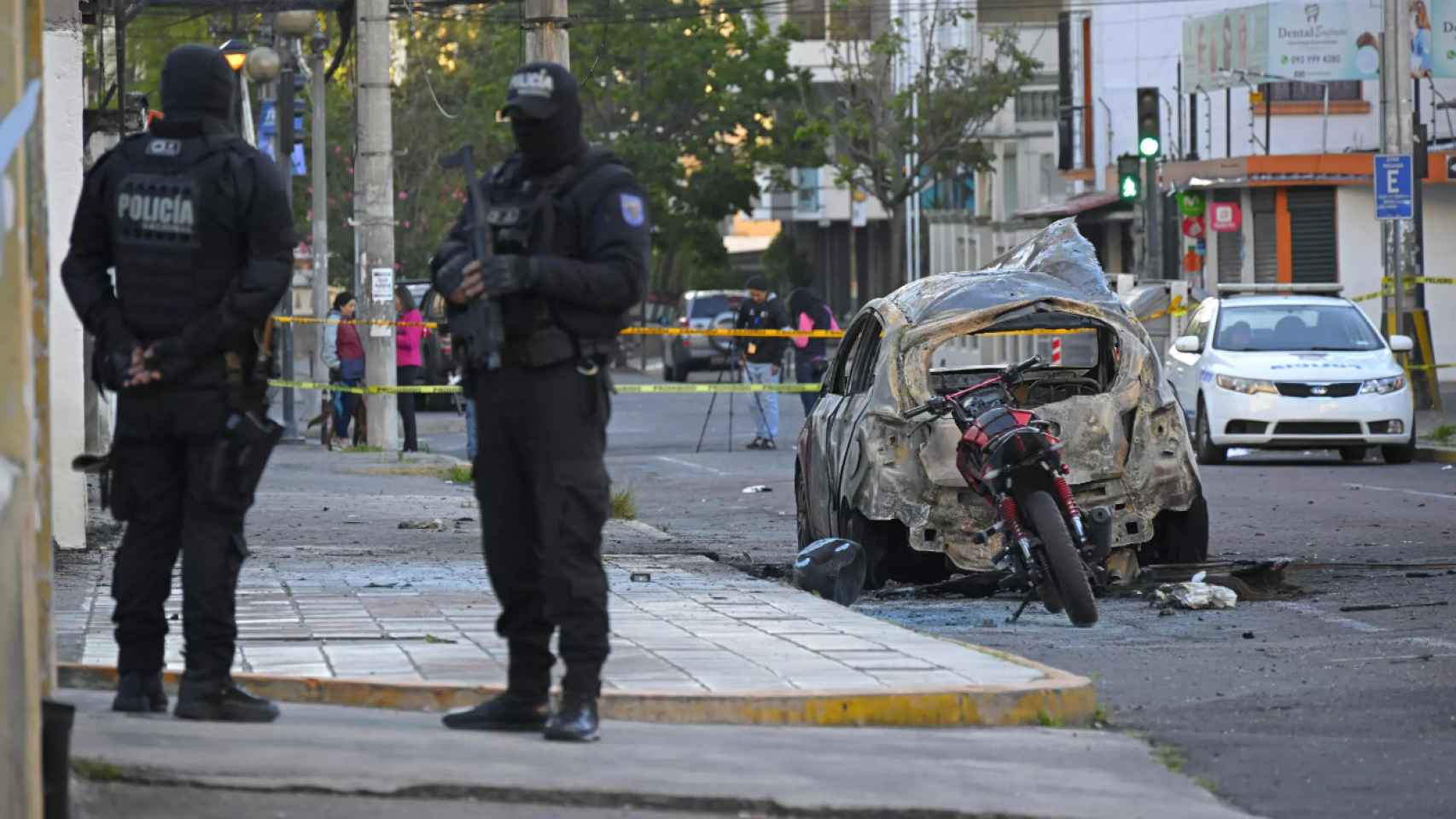 Policías vigilan cerca de los restos de un vehículo que explotó en Quito el 31 de agosto de 2023
