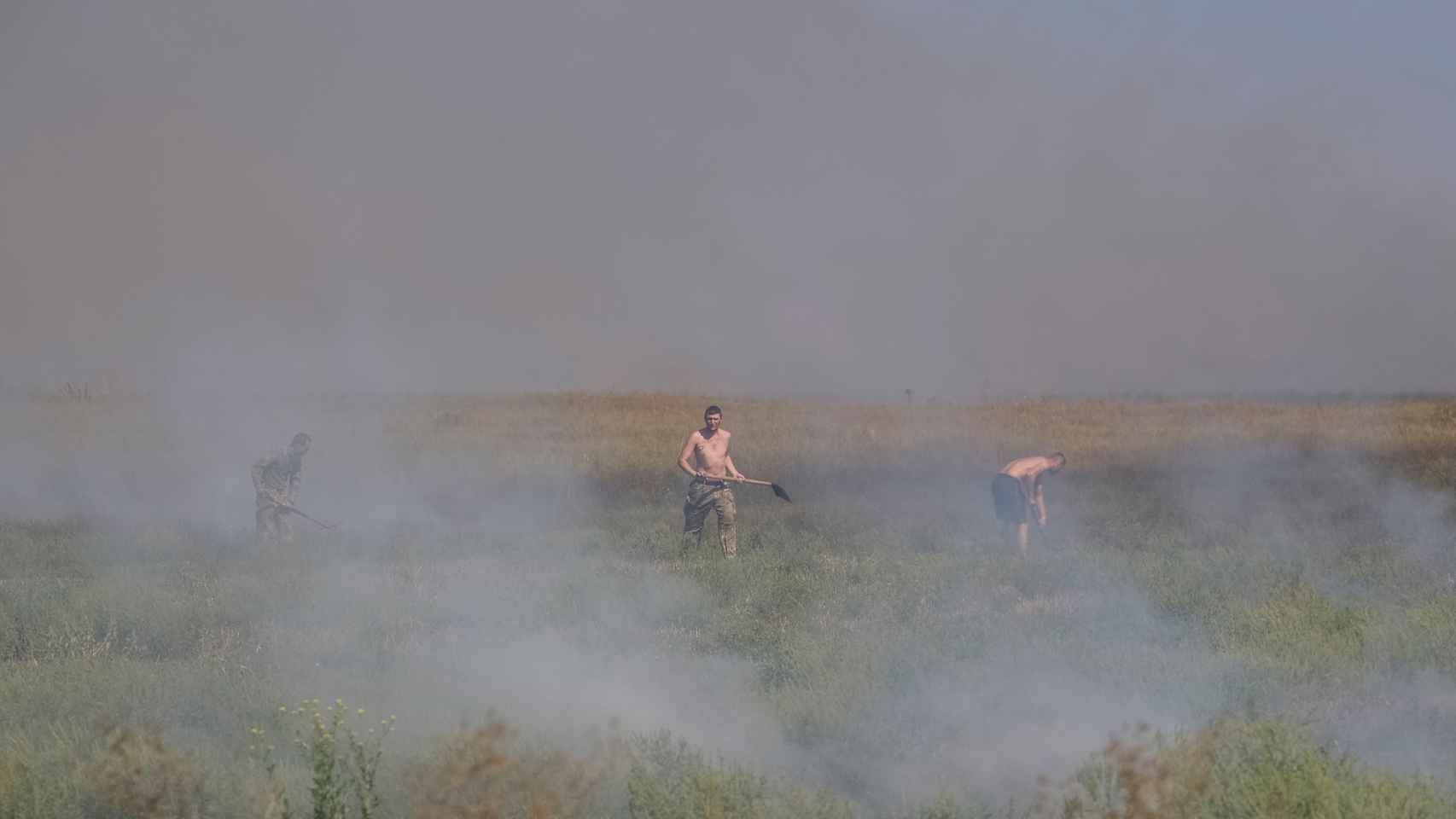 Soldados ucranianos apagan hierba quemada cerca de sus posiciones en la región de Zaporiyia.