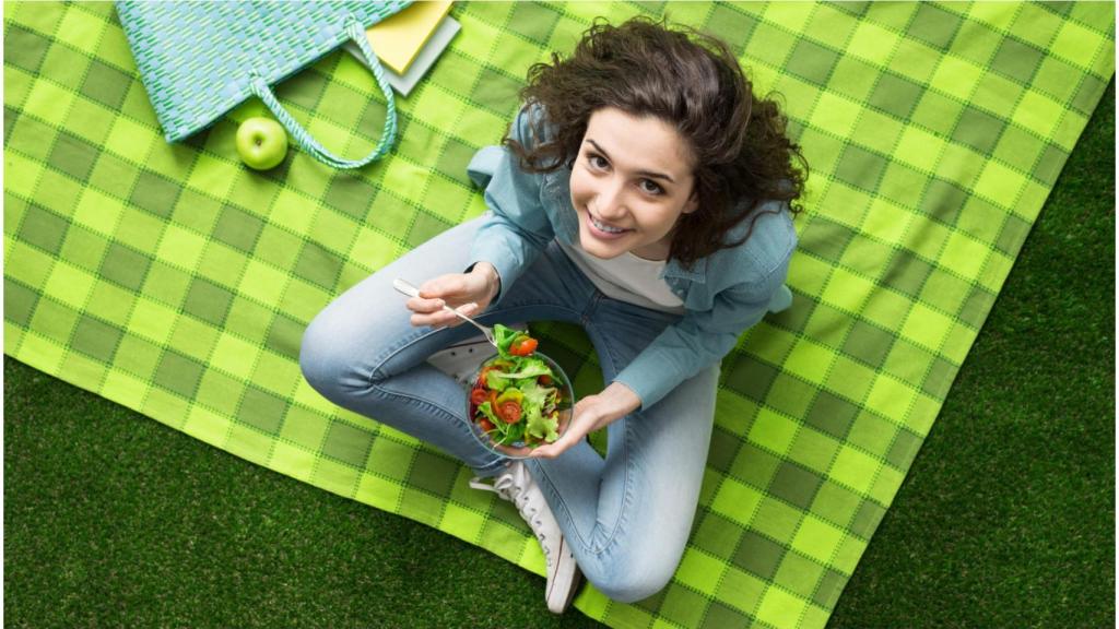 Una mujer almuerza al aire libre.