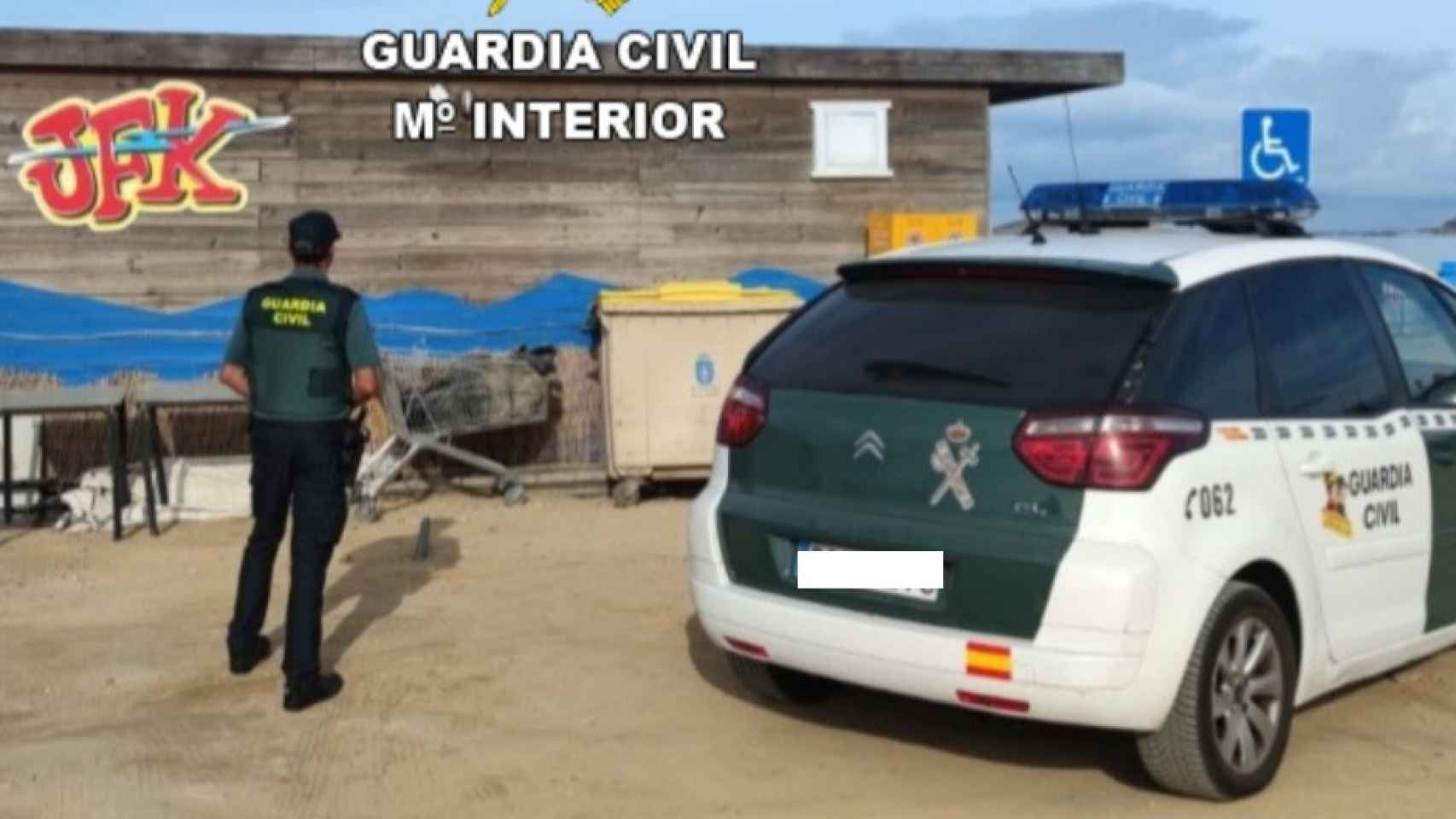 Un agente de la Guardia Civil frente al chiringuito afectado.