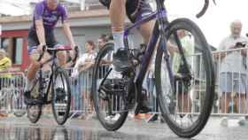 Varios corredores se ven reflejados en los charcos de agua de la calzada este sábado durante la octava etapa de la Vuelta a España