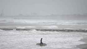 Un surfista sale del agua en la playa de Heliópolis en Benicasim, este domingo.