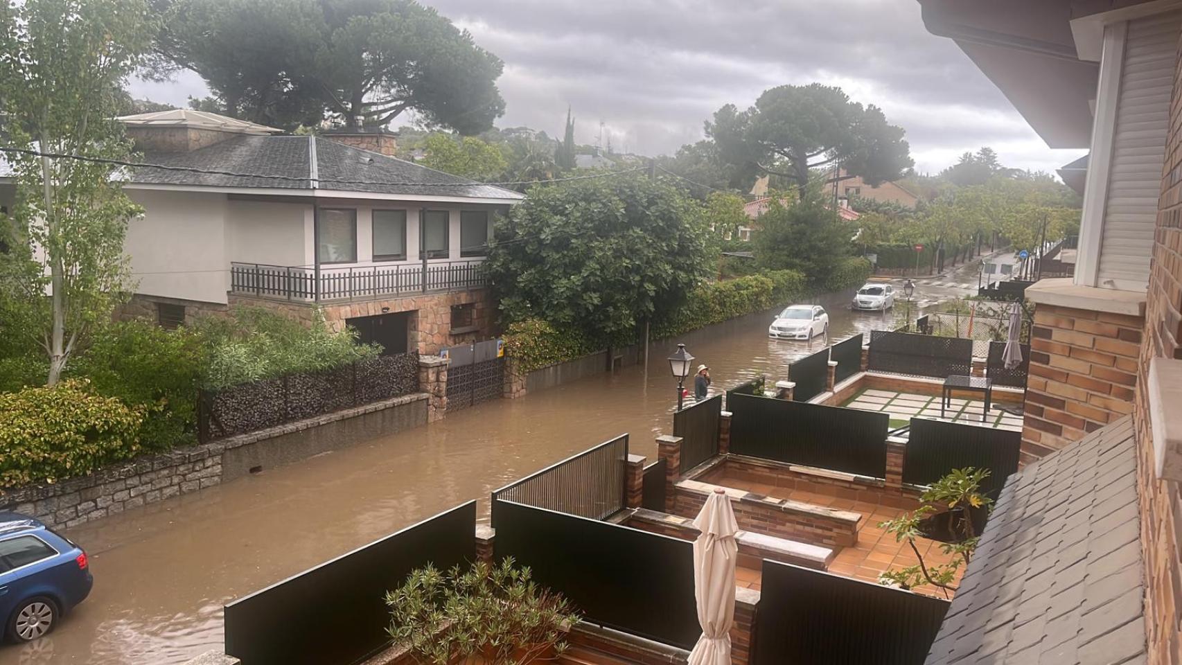 El tramo de una calle de Torrelodones, inundada este domingo por la tormenta.