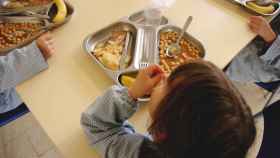 Imagen de archivo de niños comiendo en un comedor escolar. iStock