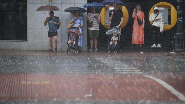 Un grupo de personas se refugia de la lluvia provocada por la DANA de septiembre de 2023