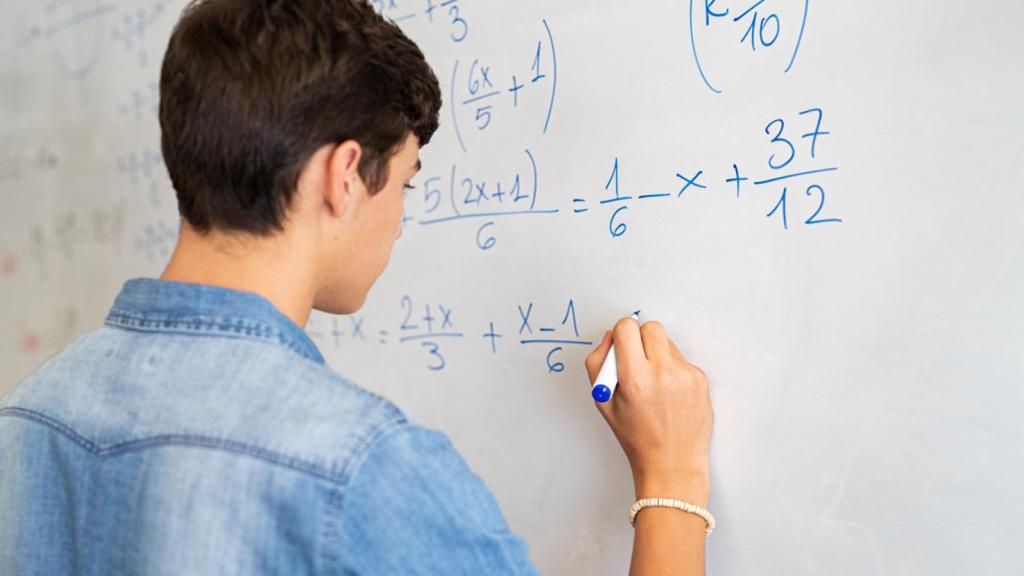 Un estudiante realiza cálculos en una pizarra.