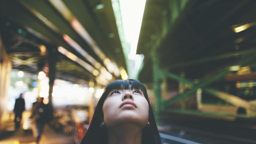 Una mujer mientras mira para arriba en la ciudad. Foto: iStock.