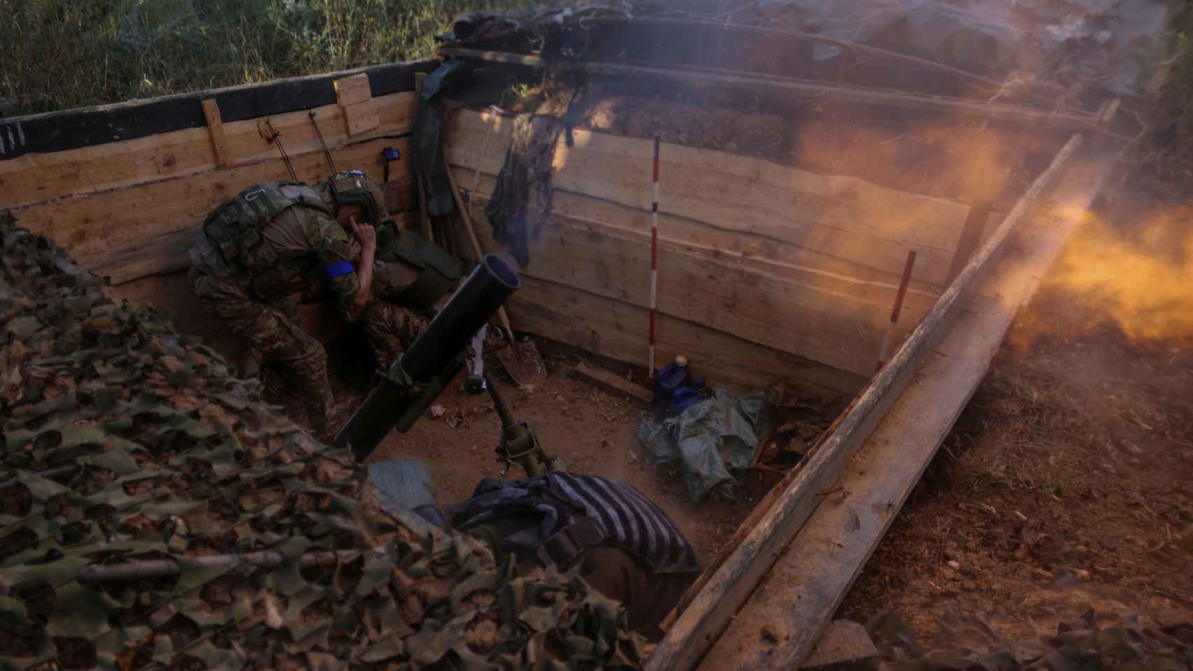 Un soldado dispara un proyectil desde una trinchera
