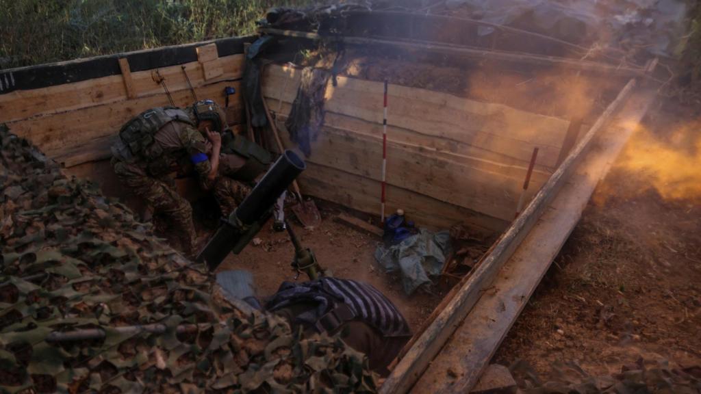 Un soldado dispara un proyectil desde una trinchera