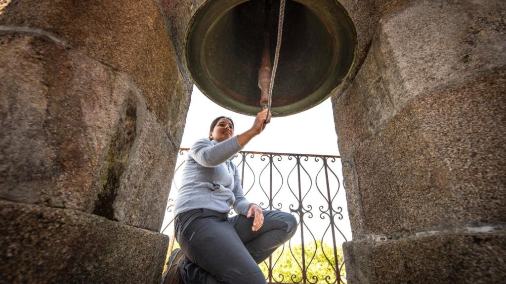 Alicia tocando la campana de la iglesia.