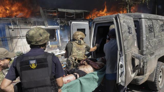 Rescatistas, sanitarios y vecinos cargan a un herido en una furgoneta, este miércoles en Kostiantinivka.