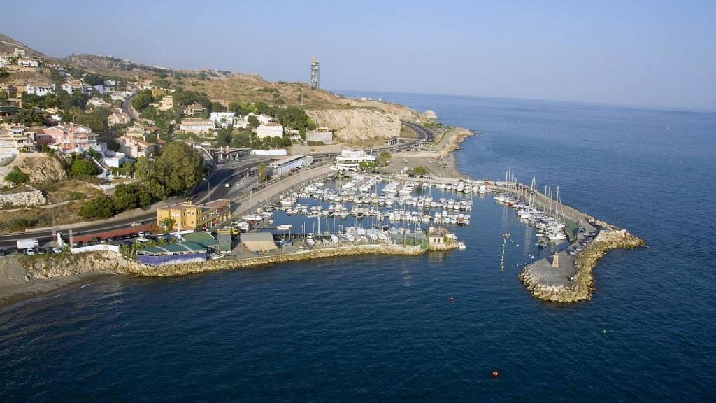 Vista del puerto deportivo El Candado, con los suelos de La Platera al fondo.